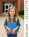 Young blonde girl with backpack holding notebook 131732774