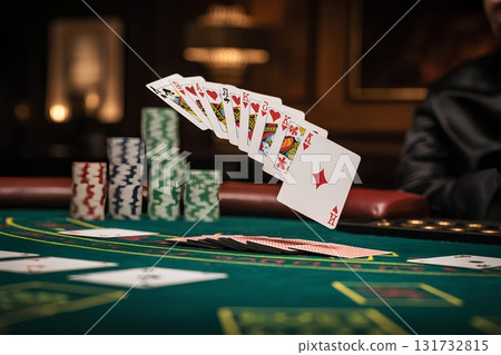 Dramatic close-up of cards levitating over casino table, high-stakes poker game with blurred background and moody lighting Dramatic close-up of cards levitating over casino table, high-stakes poker game with blurred background and moody lighting 131732815