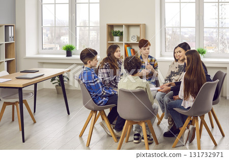 School children together with their teacher discussing something in the classroom School children together with their teacher discussing something in the classroom 131732971