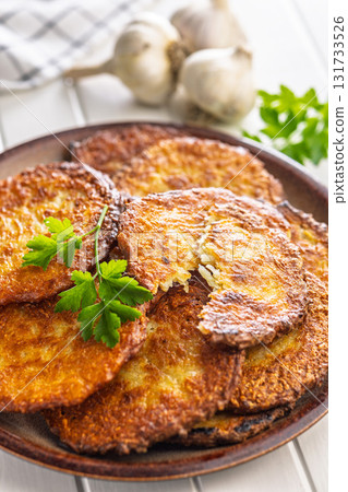 Fried potato pancakes on plate on white table. Fried potato pancakes on plate on white table. 131733526