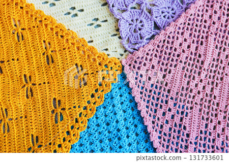 Lots of colorful hand-made crocheted scarves and kerchiefs with different patterns 131733601