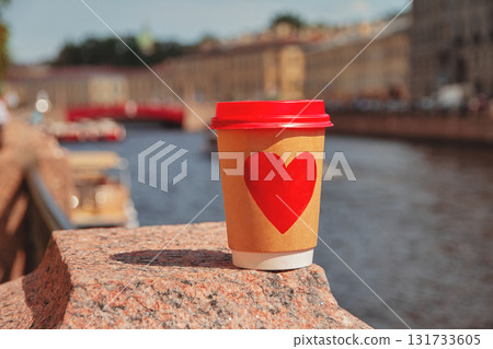 Brown cup of natural coffee with red heart on bridge near embankment of Fontanka river in St. Petersburg Brown cup of natural coffee with red heart on bridge near embankment of Fontanka river in St. Petersburg 131733605