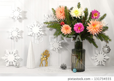 New Year's mockup for product design and display, a creative Christmas bouquet of fresh fir branches in a vase with chrysanthemum flowers and decorations on festive background. Christmas Eve concept New Year's mockup for product design and display, a creative Christmas bouquet of fresh fir branches in a vase with chrysanthemum flowers and decorations on festive background. Christmas Eve concept 131734555