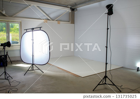 Photo zone in a factory corner for product photography, with studio strobes and a large softbox Photo zone in a factory corner for product photography, with studio strobes and a large softbox 131735025