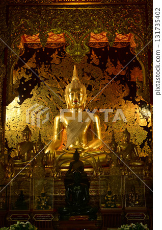 The golden sitting statue of Phra Kaew Klao Chao Bun Rueang Buddha is enshrined in a teakwood chapel at Wat Den Sali Si Mueang Kaen temple or Wat Ban Den. Located at Chiang Mai Province in Thailand. 131735402