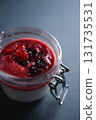 berry panna cotta dessert with cherry sauce in glass jar on black background 131735531