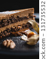 closeup of chocolate nut cake with walnut and physalis on black plate 131735532