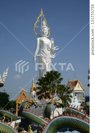 Phra Phutthaphon Sri Asvamuni, a 28-meter-high standing Buddha statue bestowing blessings at Wat Nong Jab Tao is a temple with a beautiful white ordination hall. Phra Phutthaphon Sri Asvamuni, a 28-meter-high standing Buddha statue bestowing blessings at Wat Nong Jab Tao is a temple with a beautiful white ordination hall. 131735758