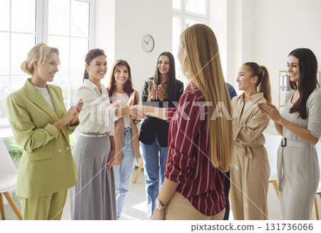 Group of professional women in office applauding and shaking hands, celebrating success together. Group of professional women in office applauding and shaking hands, celebrating success together. 131736066