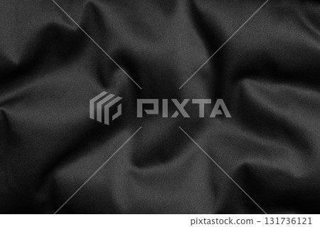 Black fabric texture with soft folds and smooth surface, close-up background Black fabric texture with soft folds and smooth surface, close-up background 131736121