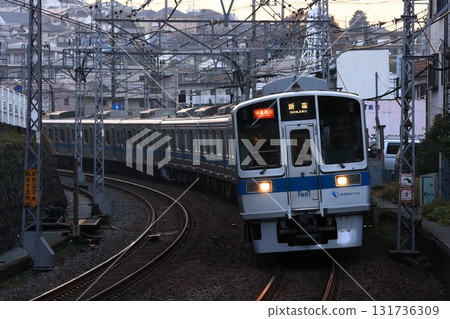 暮色中，小田急1000系列車在多摩丘陵的映襯下，車頭燈閃爍，飛馳而過。照片拍攝於2010年12月14日 131736309