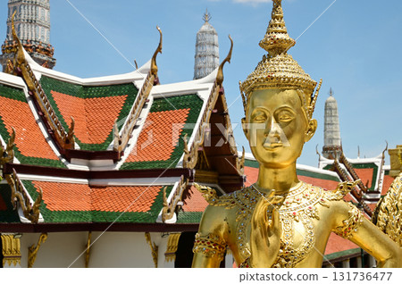 The face of golden Kinnari statue at Wat Phra Kaew. Kinnari are half-bird, half-woman creatures from Buddhist mythology. Wat Phra Kaew is a famous tourist attraction. The face of golden Kinnari statue at Wat Phra Kaew. Kinnari are half-bird, half-woman creatures from Buddhist mythology. Wat Phra Kaew is a famous tourist attraction. 131736477