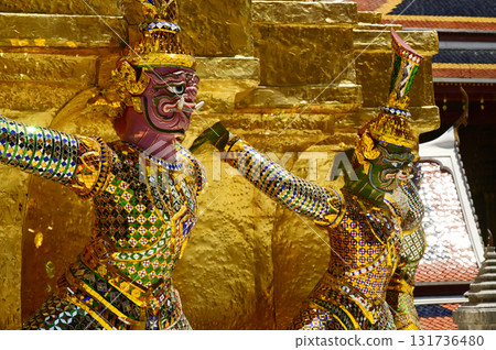 The large giant guardian standing guard carrying the pagoda base at Wat Phra Kaew Temple of the Emerald Buddha is a famous tourist attraction. Bangkok Thailand. The large giant guardian standing guard carrying the pagoda base at Wat Phra Kaew Temple of the Emerald Buddha is a famous tourist attraction. Bangkok Thailand. 131736480