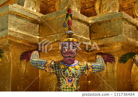 The large giant guardian standing guard carrying the pagoda base at Wat Phra Kaew Temple of the Emerald Buddha is a famous tourist attraction. Bangkok Thailand. The large giant guardian standing guard carrying the pagoda base at Wat Phra Kaew Temple of the Emerald Buddha is a famous tourist attraction. Bangkok Thailand. 131736484
