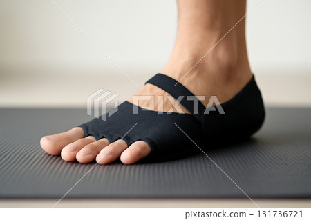 AI generated close-up of a foot in a minimalist shoe pressing into a yoga mat, highlighting grounding and form. Soft lighting accentuates texture, offering a calming, focused vibe. AI generated close-up of a foot in a minimalist shoe pressing into a yoga mat, highlighting grounding and form. Soft lighting accentuates texture, offering a calming, focused vibe. 131736721