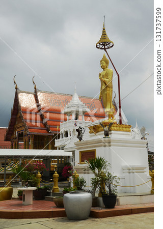 A golden standing outdoor Buddha front of a pavilion or temporary shed at Wat Nong Yai. Located at Chon Buri Province in Thailand. A golden standing outdoor Buddha front of a pavilion or temporary shed at Wat Nong Yai. Located at Chon Buri Province in Thailand. 131737599