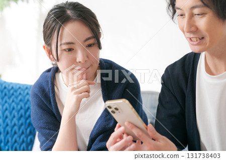 20 多歲的男女正在看智慧型手機 131738403