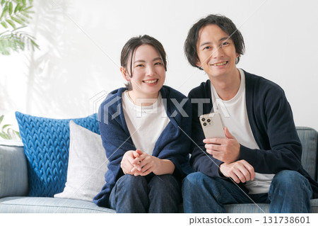 Men and women in their 20s looking at their smartphones 131738601