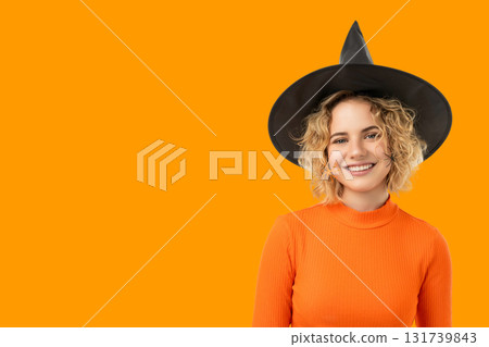 Cheerful woman dressed in Halloween costume with festive hat 131739843