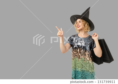 Woman wearing a witch hat and sequined dress enjoys Halloween Woman wearing a witch hat and sequined dress enjoys Halloween 131739911