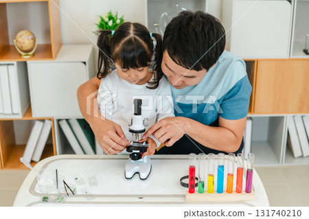 father and toddler girl scientist placing microscope slides with specimen. learning science 131740210