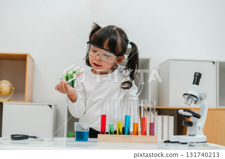 toddler girl scientist study using pipette dropping liquid with test tube and beaker. learning science 131740213