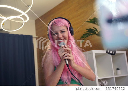 Beautiful young singer and musician broadcast from her home studio 131740312