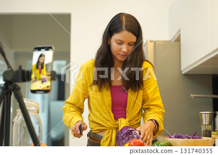 Young woman is broadcasting live from workshop how to prepare a vegetarian food Young woman is broadcasting live from workshop how to prepare a vegetarian food 131740355
