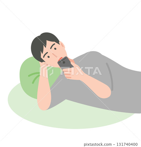 A man using a smartphone while lying down A man using a smartphone while lying down 131740400