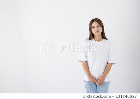 A young woman with a serious expression in front of a white background A young woman with a serious expression in front of a white background 131740658