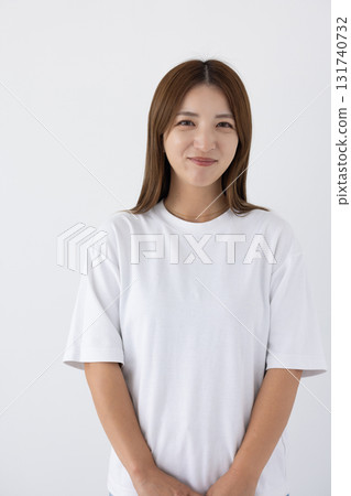Young woman smiling in front of a white background Young woman smiling in front of a white background 131740732