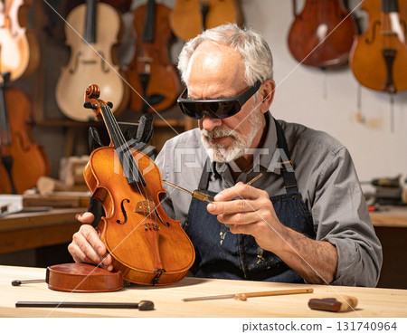 AI generated image of an elderly luthier working in a classic violin workshop using augmented reality glasses for precision. The blend of tradition and modern technology creates a perfect harmony. 131740964