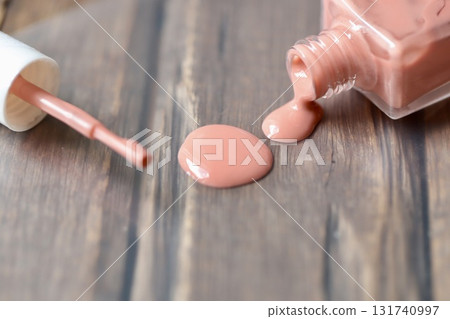 Beige-pink nail polish spilled from a container Beige-pink nail polish spilled from a container 131740997