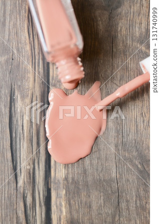 Beige-pink nail polish spilled from a container 131740999