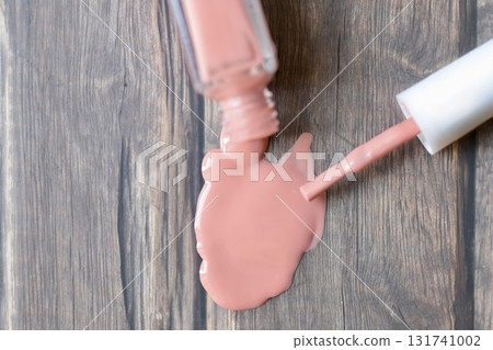Beige-pink nail polish spilled from a container 131741002