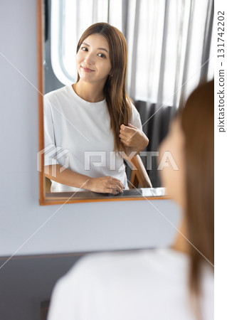 年輕女子在鏡子前做頭髮 131742202