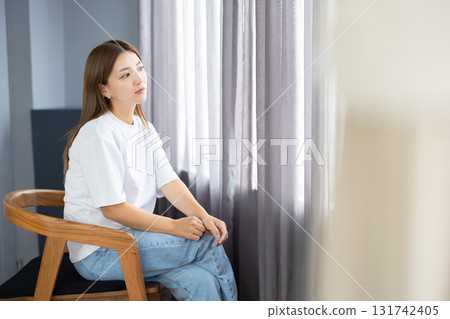 沉思的年輕女子坐在椅子上 131742405