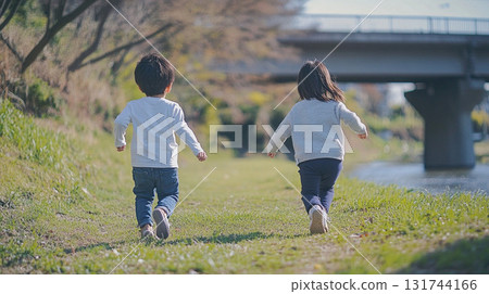 Children running along the river 131744166