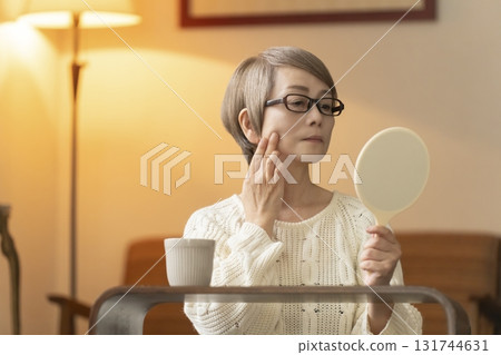 晚上，老年婦女在客廳看著手鏡 131744631