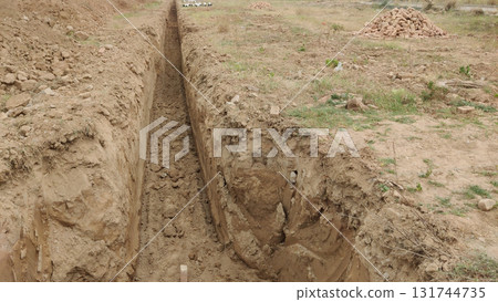Perspective view of a newly dug trench in a dirt field under daylight conditions Perspective view of a newly dug trench in a dirt field under daylight conditions 131744735