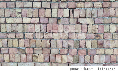 Close up view of a brick wall with light brown and tan colored bricks 131744747