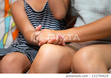 Close Up of Asian Mother Holding Daughter's Hand with Love and Care 131744829