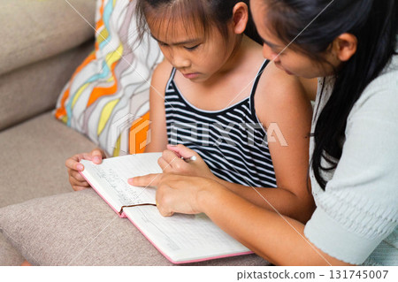 Asian Mother Teaching Her Daughter to Write at Home Asian Mother Teaching Her Daughter to Write at Home 131745007