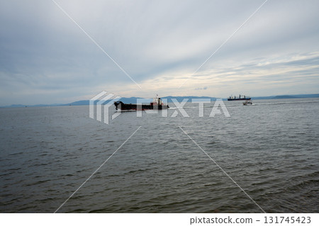 Boats navigate the waters of Vladivostok's scenic coastline at dusk 131745423