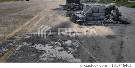 Scattered cement blocks lying unevenly on a road surface in daylight with shadows highlighting rough textures 131746401