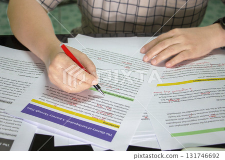 hand holding red pen to do proofreading 131746692