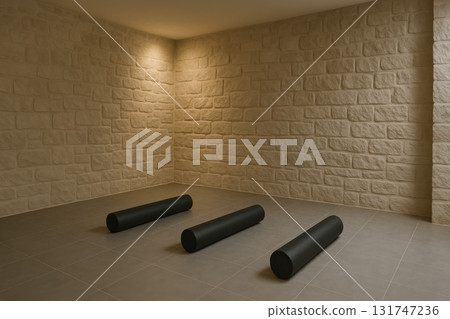 Modern yoga room with stone walls and three black foam rollers on gray tiled floor, creating calm minimalist interior with soft warm lighting for relaxation and exercise Modern yoga room with stone walls and three black foam rollers on gray tiled floor, creating calm minimalist interior with soft warm lighting for relaxation and exercise 131747236