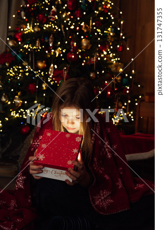 Christmas Surprise Moment with Gift Box. Excited Child Holding Red Christmas Present. holiday excitement, winter warmth, and joyful seasonal celebration Christmas Surprise Moment with Gift Box. Excited Child Holding Red Christmas Present. holiday excitement, winter warmth, and joyful seasonal celebration 131747355