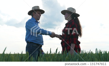 Business deal in wheat field, Successful partnership handshake, Mens handshake in the country, Agreement on agricultural business, Farming cooperation under the sky, Rural deal and negotiation 131747811