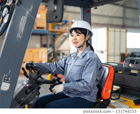 Female worker driving a forklift 131748155